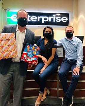 Employees wearing masks and holding food donations